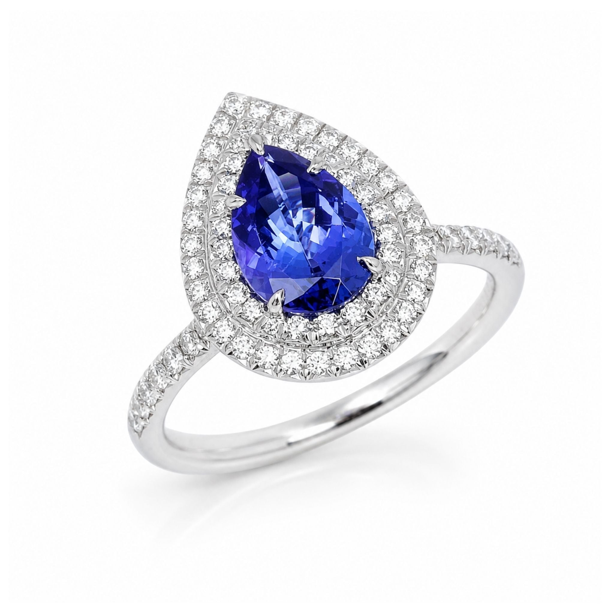 A pear-shaped tanzanite ring in a double halo setting with a silver-colored band paved with diamonds 
es, shown on a white background.