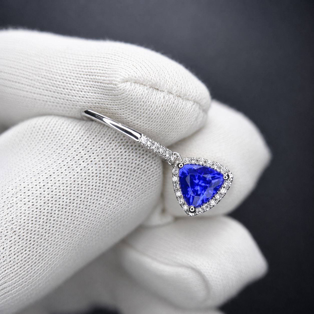 AAA grade trillion cut tanzanite earrings showcasing a matching pair of natural tanzanites surrounded by diamonds.